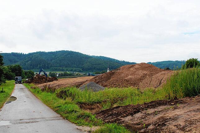 Der Baulaster verdeutlicht, wie hoch das Erdreich neben dem landwirtschaftlichen Weg, der auch als Radweg ausgewiesen ist, schon ...