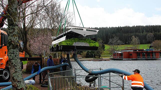 Die Zirkulationsanlage schwebt über dem Klosterweiher. Sie wird dort, wo der Ablauf des Weihers ist, ins Wasser gesetzt. Die Schläuche ...
