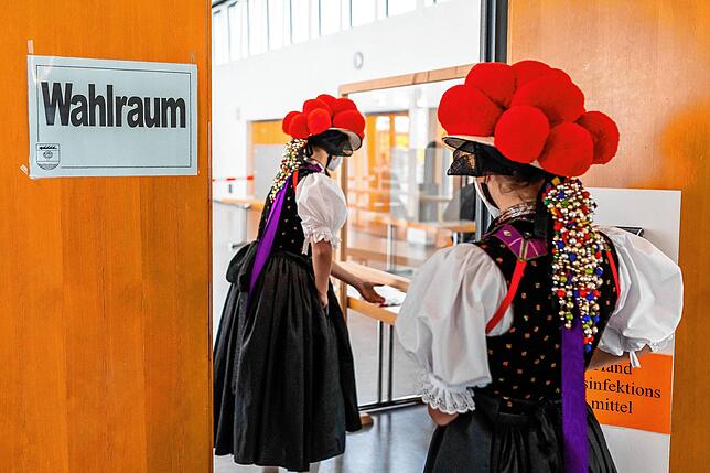 Ein Blickfang und schon von weitem zu sehen: Zwei junge Frauen in traditioneller Schwarzwälder Tracht stehen in der Festhalle in Gutach ...
