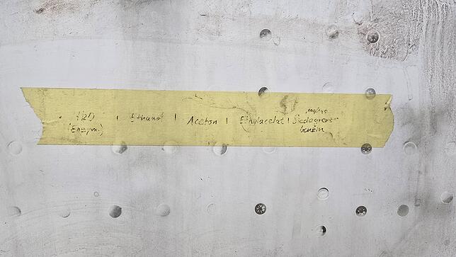 Auf einem Klebestreifen sind die unterschiedlichen Reinigungsmittel notiert, deren Wirkung die Restauratoren an einer Stelle des Rumpfes ...