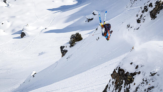 Ein Freeride-Skifahrer springt abseits der Piste in den Schweizer Alpen durch die Luft.