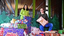 Antonia Musacchio-Torzilli und Dennis Schulze inmitten der vielen Geschenke, die die Geschenkepaten für die Wunschbaumaktion stifteten.