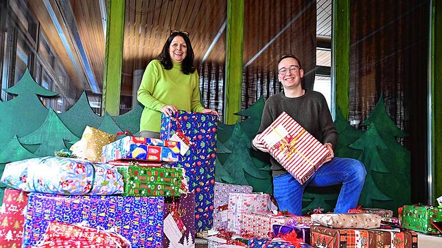 Antonia Musacchio-Torzilli und Dennis Schulze inmitten der vielen Geschenke, die die Geschenkepaten für die Wunschbaumaktion stifteten.