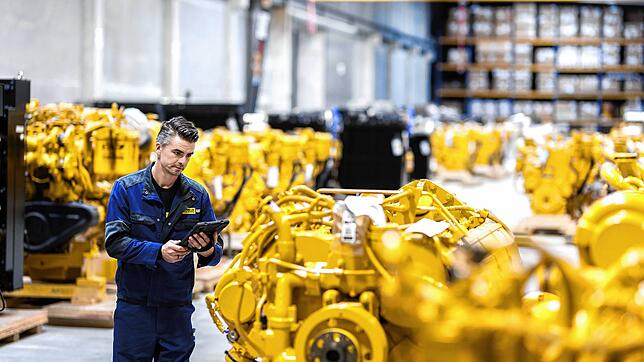 Ein Mitarbeiter der Zeppelin-GmbH prüft Caterpillar-Großmotoren für Baufahrzeuge. Zeppelin Deutschlands größter Händler für die gelben ...
