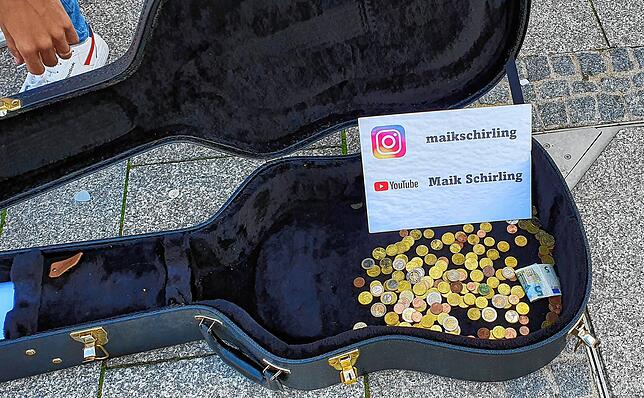 Der junge Straßenmusiker kommt gut an bei den Passanten in Villingen. Münze um Münze landet in seinem Gitarrenkoffer.