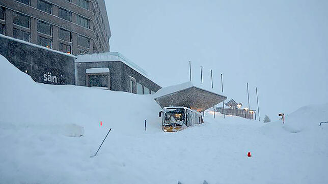 Ein Bus steht nach einem Lawinenabgang halb schneebedeckt vor dem Eingang zum Hotel Säntis auf der Schwägalp.