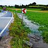 Das Wasser zieht sich bei Aasen wieder zurück. Nach einem heftigen Starkregen war die Straße überspült. Die Feuerwehr sichert den Bereich.