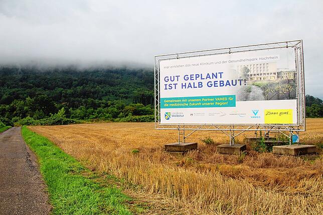 Ein Schild weist auf den geplanten Gesundheitspark Hochrhein auf dem Gelände zwischen Rhein und Papierfabrik Albbruck hin.