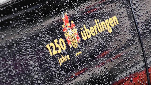 Auf der regennassen Dienstkarosse des Überlinger Oberbürgermeisters prangt dieser Aufkleber &bdquo;1250 Jahre Überlingen&ldquo;. Die ...