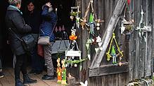 Besucher des Ostermarkts im Freilichtmuseum plaudern im Eingang zum Wagenschopf miteinander.