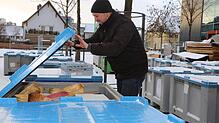 Frank Schuhwerk von Event-Promotions packt Dekomaterial in große Boxen ein.