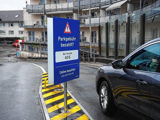„Parkgebühr bezahlt?“ Das fragt ein Schild beim Ausfahren und warnt vor den Folgen, wenn die Zahlung ausbleibt.