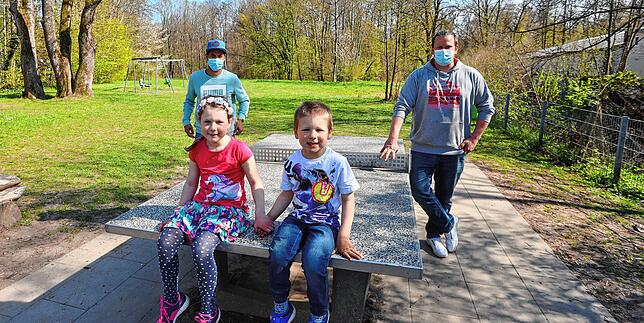 Stella und Diego sitzen auf der Tischtennisplatte auf dem weitläufigen, aber recht einsam und öde daher kommenden Spielplatz beim ...