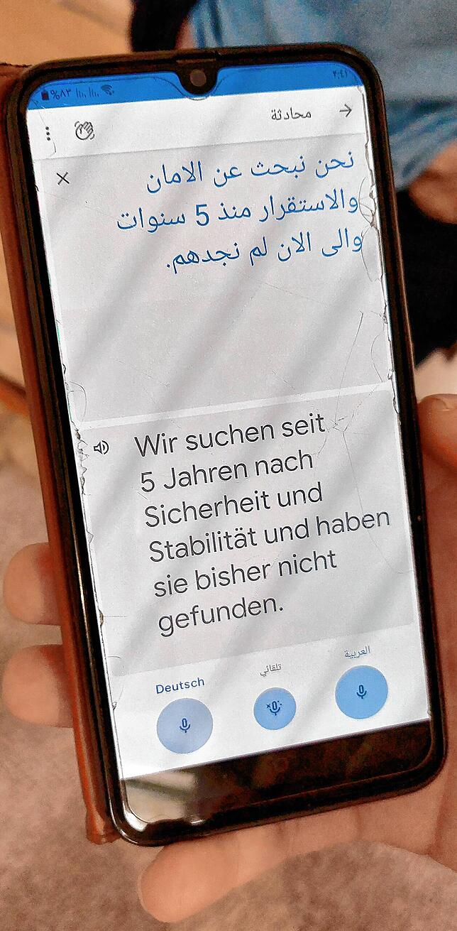 Hussein Al Radi Al Eneze spricht in sein Telefon. Eine App übersetzt seine Worte ins Deutsche: „Wir suchen seit fünf Jahren nach ...