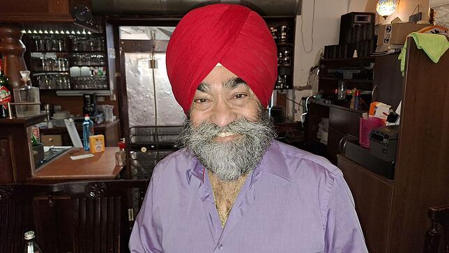 Anoop Singh Mudher vor der Theke und dem Zugang zur Küche im Sitara.