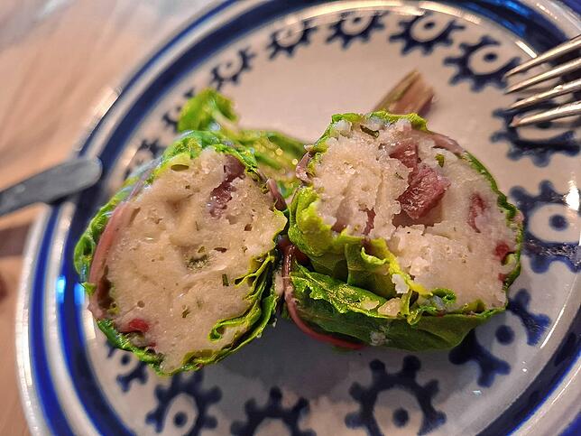Aufgeschnitten in zwei Hälften: ein Capun. Gefüllt ist es mit Salsiz eine luftgetrocknete oder geräucherte Rohwurst aus dem Kanton ...