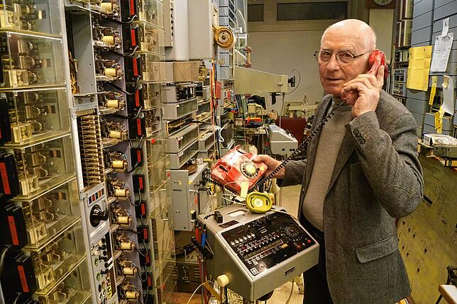 Hans-Dieter Schmidt steht vor einer Auswahl seiner Fernmeldesammlung. Er hat die Apparate über mehrere Jahrzehnte hinweg zusammengetragen.