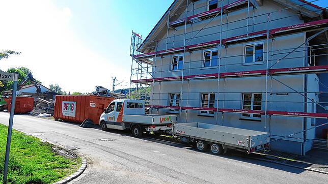 Hinter den Containern standt die abgebrannte Produktionshalle der Schreinerei. Am eingerüsteten Wohnhaus laufen derzeit die Arbeiten, um ...