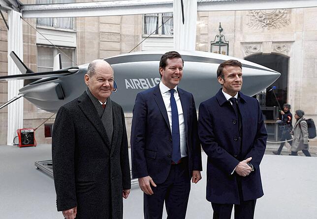 Frankreichs Präsident Emmanuel Macron (rechts), Bundeskanzler Olaf Scholz (links) und Bruno Fichefeux, FCAS-Programmchef bei Airbus, ...