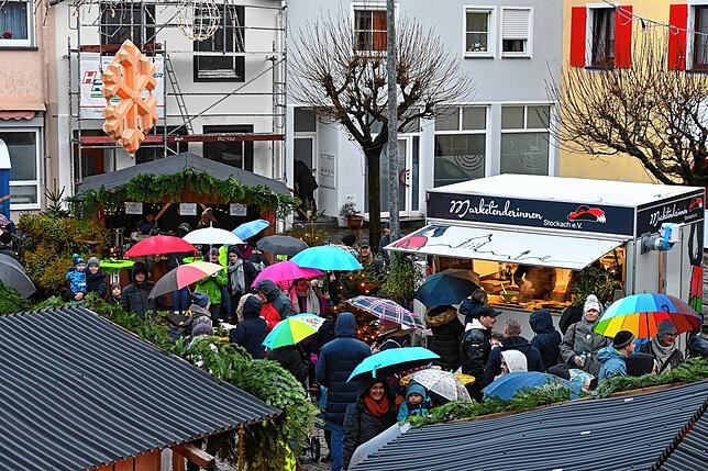 Auf dem Platz beim Winterzauber regieren die Regenschirme.