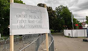Am Gelände neben dem Konzertsegel weist ein Schild auf die Absage hin.