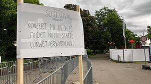 Am Gelände neben dem Konzertsegel weist ein Schild auf die Absage hin.