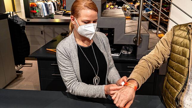 Nadine Müller vom Modehaus Broghammer legt einem Kunden den neuen Bändel ums Handgelenk. Seit Ende November können Kunden in einem ...