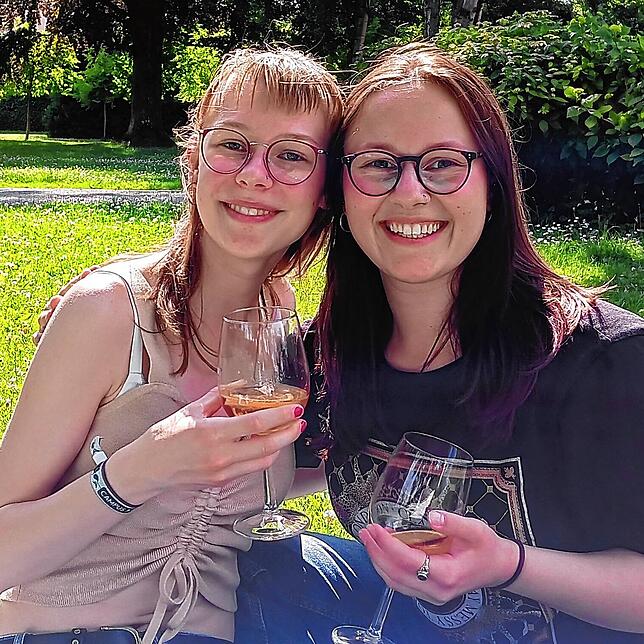Marie Stracke (links) und Lina Schmitz haben es sich mit einem Getränk auf der Wiese gemütlich gemacht und warten jetzt darauf, endlich ...