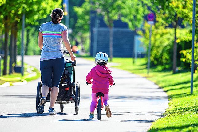 Eine Frau joggt mit ihren Kindern, die eigentlich in der Kita wären, auf einem Weg. Maximal 50 Prozent der Kinder dürfen seit 18. Mai ...