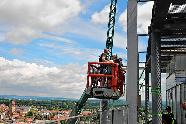 Hoch über Singen neben der Fassade des Hegau-Towers schwebt der Transportkorb.