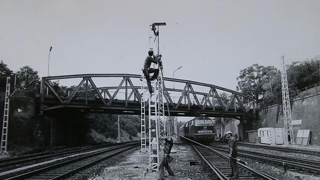 1976: Die Masten für die elektrischen Oberleitungen werden im Bahngraben in Radolfzell aufgestellt. Rechts muss eine Diesellok auf ihrer ...