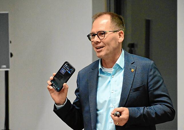 Bürgermeister Thorsten Scigliano zeigt in seinem Vortrag über Mini-PV-Anlage, wie er mit einer App den Stromverbrauch zuhause jederzeit ...