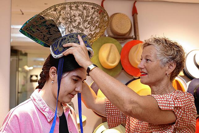 Andächtiger Moment: Erste Anprobe der neu gefertigen Radhaube von Sarah Grünfelder durch Hutmacherin Carolin Engel.