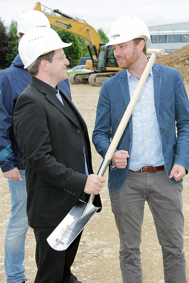 Einen beschrifteten Spaten übergibt Daniel Kurzius (rechts) von der Firma Mörk zum Baustart an Tobias Walderich von der Gnadenkirche, ...
