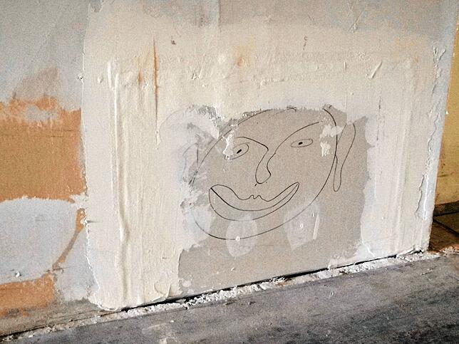 Zeichnung im Oberstübchen des Sanatoriums. Bleistift-Notizen finden sich an vielen der baufälligen Wänden. Eine Wand wurde mit ...