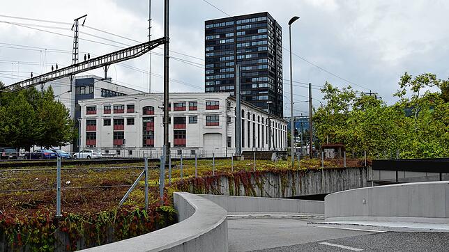 Die Padel-Hallen entstehen im hellen Gebäude mit den hohen Fenstern (Ansicht vom Bahnhof/Postgebäude her).