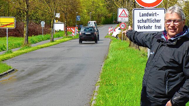 Peter Weimer steht vor dem Schilderwald: Links das Ortsschild-Ende Bergheim, direkt danach das Tempo 70-Schild mit dem zusätzlichen ...