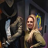 Bar-Besitzerin Liana Nienaber schmiegt sich an eine Mafia-Figur, die gerade eine Pistole lädt.