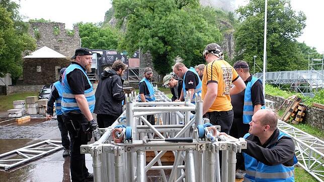 Im doppelten Sinne für die Sicherheit im Einsatz sind die Männer der Firma SSK: Hier bauen sie die Träger der Hauptbühne auf der ...