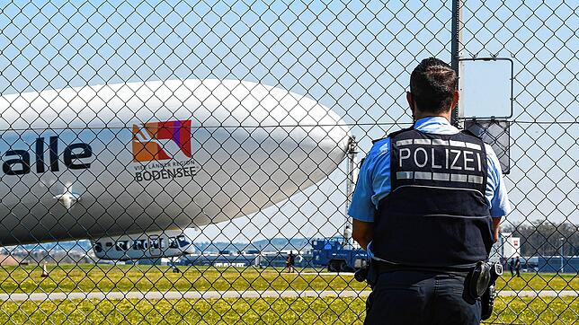 Ein Polizist verfolgt am Karfreitag vom Zaun aus den Start des Zeppelin NT.