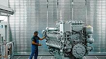 Ein RRPS-Mitarbeiter prüft einen riesigen Dieselmotor der 4000er-Baureihe nach der Lackierung. Unter anderem diese Motorenbaureihe, die ...