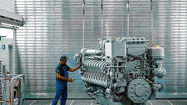 Ein RRPS-Mitarbeiter prüft einen riesigen Dieselmotor der 4000er-Baureihe nach der Lackierung. Unter anderem diese Motorenbaureihe, die ...
