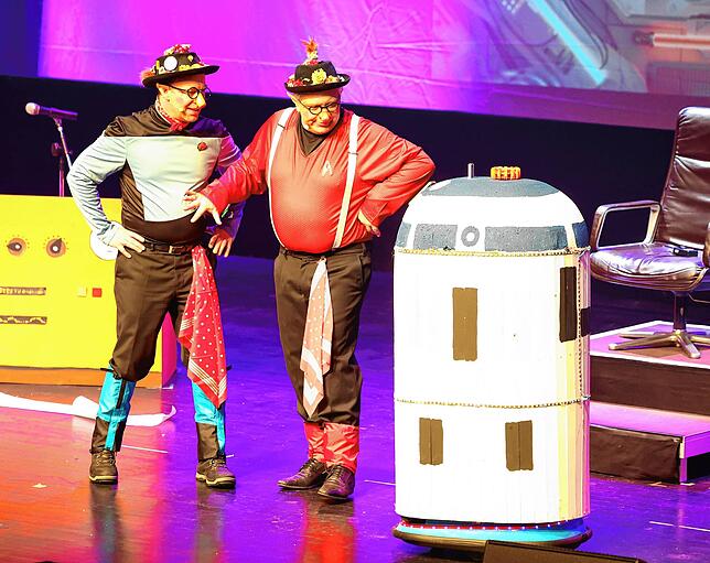 Ignaz (Markus Kuttruff) und Severin (Thomas Höfler) haben Untersützung von Kiara erhalten. Der kleine Roboter gibt aber auch Widerworte.
