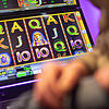 Ein Mann sitzt an einem Spielautomaten. Zu den Gewinnern gehören der Betreiber des Geräts und die Gemeinde &ndash; wenn sie denn ...