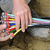 ARCHIV – ILLUSTRATION – Ein Mann fächert 10.05.2010 unter einer Straße in München (Bayern) ein Glasfaser-Kabel mit farbigen ...