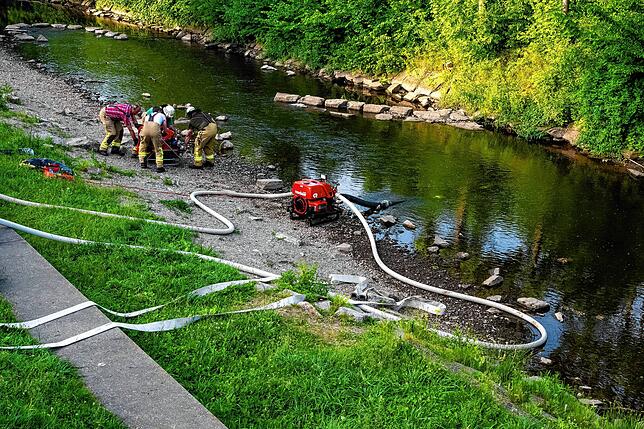 Feuerwehrleute zapfen die Brigach für die Versorgung mit Löschwasser an.