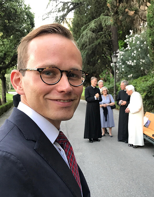 Fabian Huber auf dem Campus Santo in Rom. Im Hintergrund Papst Emeritus Benedikt XVI. und Georg Gänswein.
