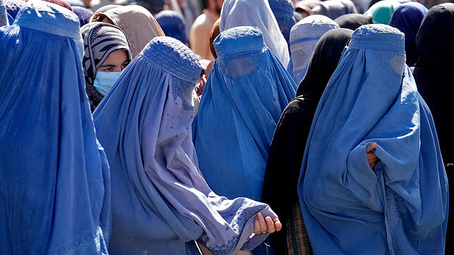 Afghanische Burkaträgerinnen warten in Kabul auf Lebensmittelrationen. Von nun an muss die traditionelle Verschleierung von allen ...