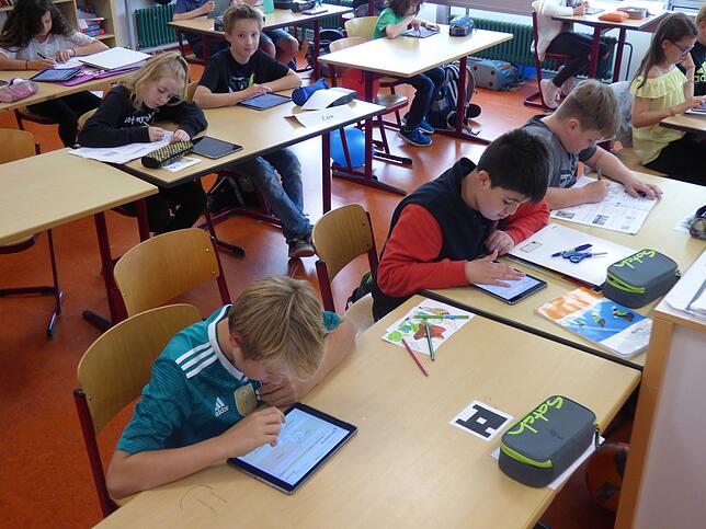 Konzentriert sitzen die Schüler der Klasse 5c über ihren Tablets. Zu einer bestimmten Aufgabe müssen sie eine Reihe von Fragen ...
