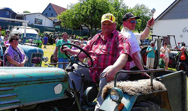 Eberhard Hauff fährt den Bulldog, Dekan Schmid segnet die Oldtimer und ihre Besitzer.